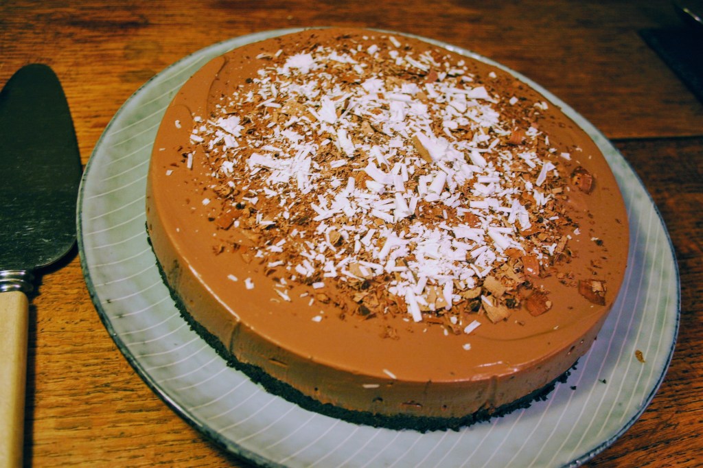 A vegan chocolate tart decorated with chocolate shavings 