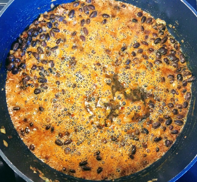 The black beans and beer, bubbling away in the frying pan.