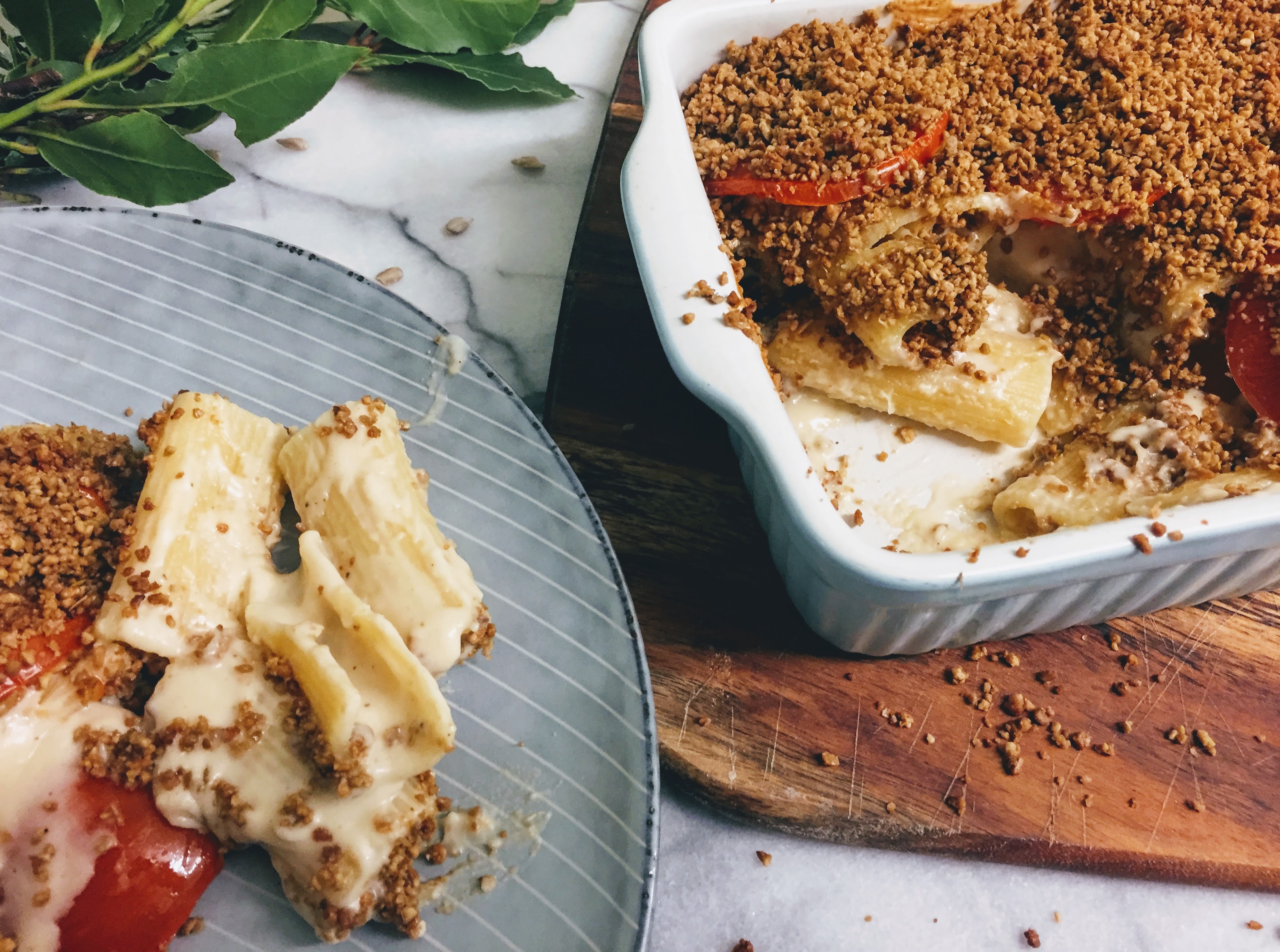 A closer view of the macaroni cheese - the pasta is large tubes of rigatoni and the sauce is creamy and smooth. you can see some flashes of red from the sliced tomatoes peaking out from under the crumble topping.