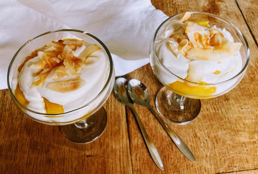 Two coupes filled with mango and coconut syllabub. 